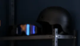 Helmet and snowboard goggles resting on a workshop shelf after cleaning