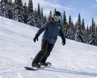 Snowboarder making a turn on a gentle groomed slope