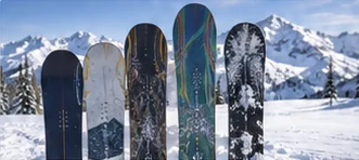 Row of snowboards of different sizes standing in the snow, for comparing kids’ snowboard sizing
