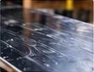 Close-up of a snowboard base being inspected during maintenance