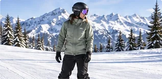 Snowboarder standing on a groomed run, representing rider weight in snowboard sizing