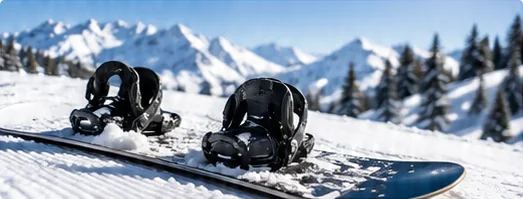 Snowboard with bindings resting on groomed snow, the area where a snowboard stomp pad and leash are fitted