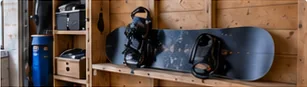 Snowboard resting on a wooden wall shelf, showing one way to store a snowboard at home