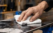 Wiping a snowboard base clean with a cloth
